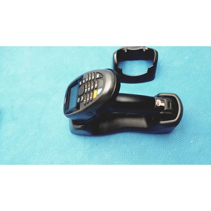 Black zebra barcode scanner mt2070-sd4d62370wr with numeric keypad and screen resting in matching battery charger dock