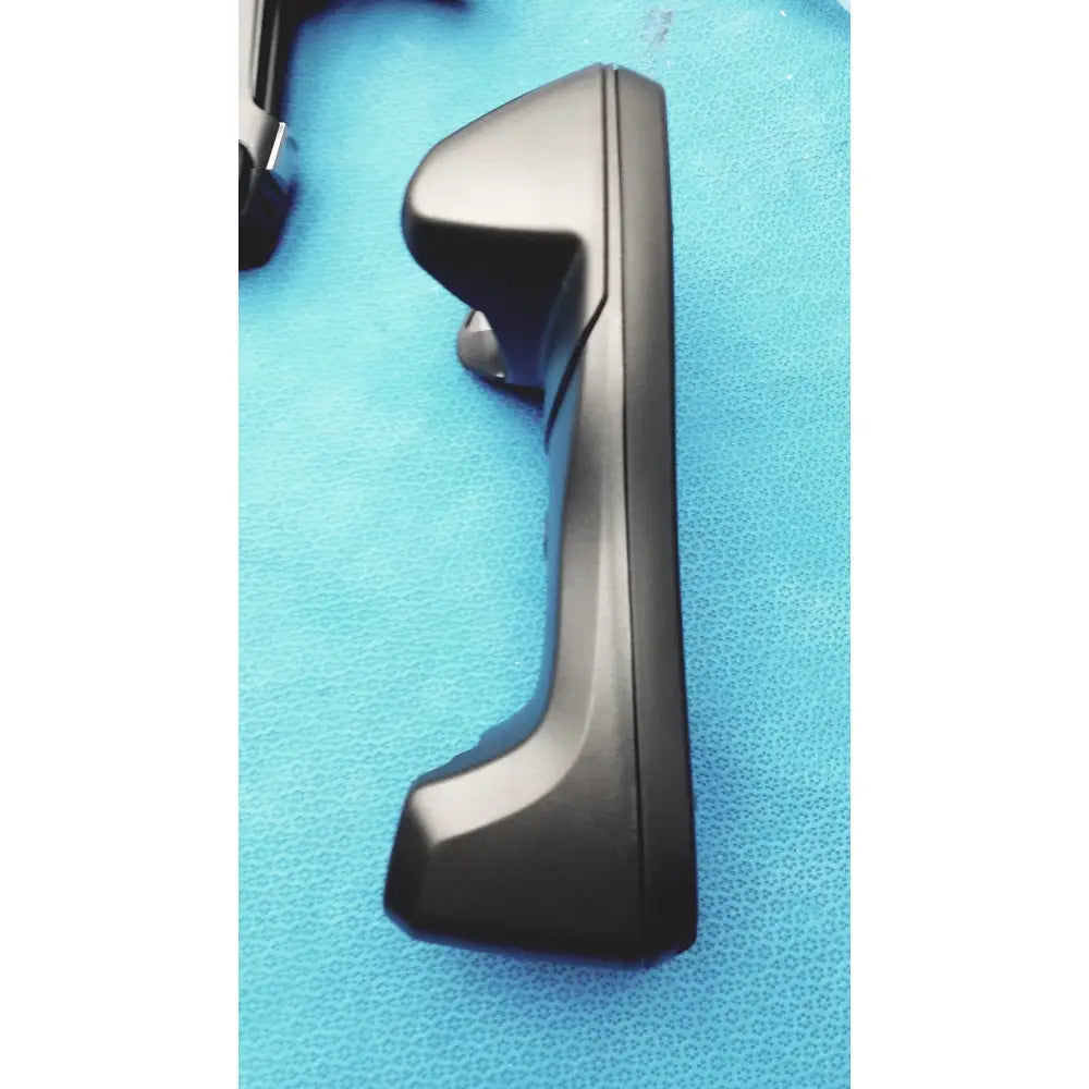 Black plastic car door handle with sleek design on the zebra barcode scanner mt2070-sd4d62370wr with battery charger