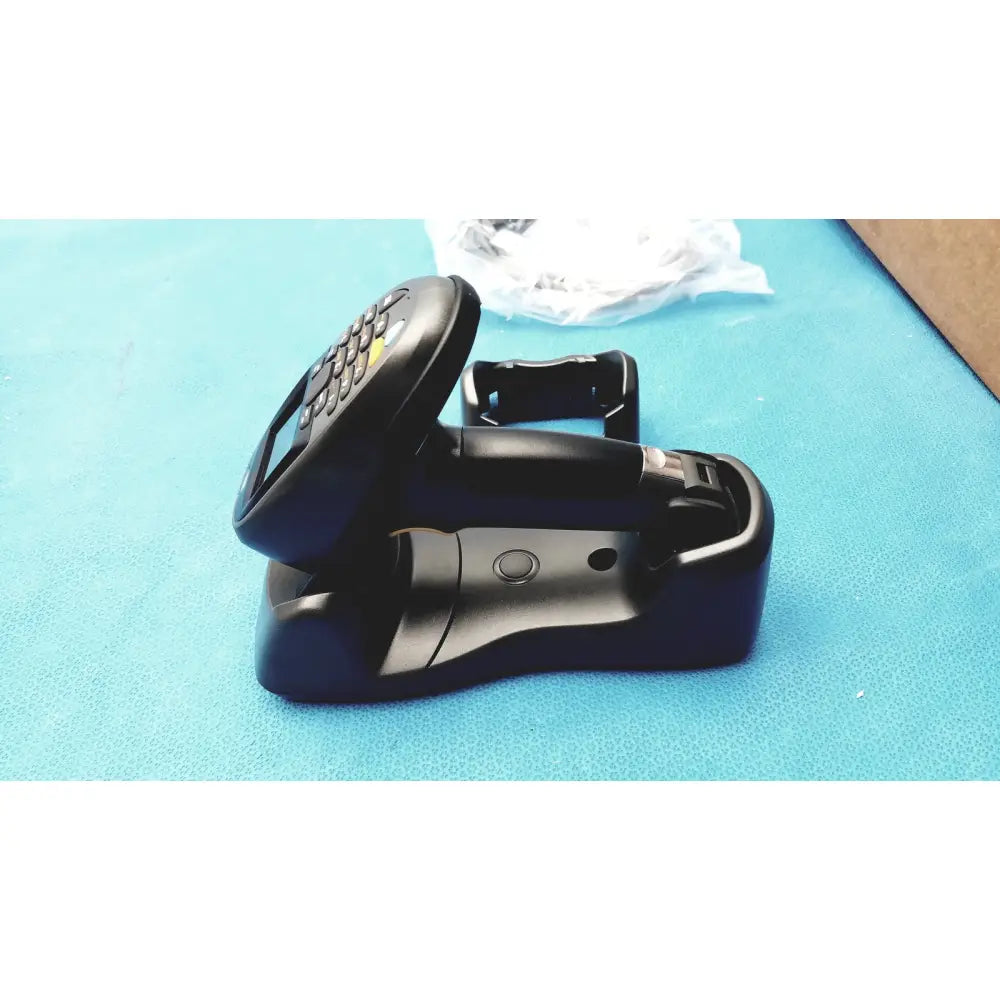 Black zebra barcode scanner mt2070-sd4d62370wr with numeric keypad and screen resting on matching charging dock