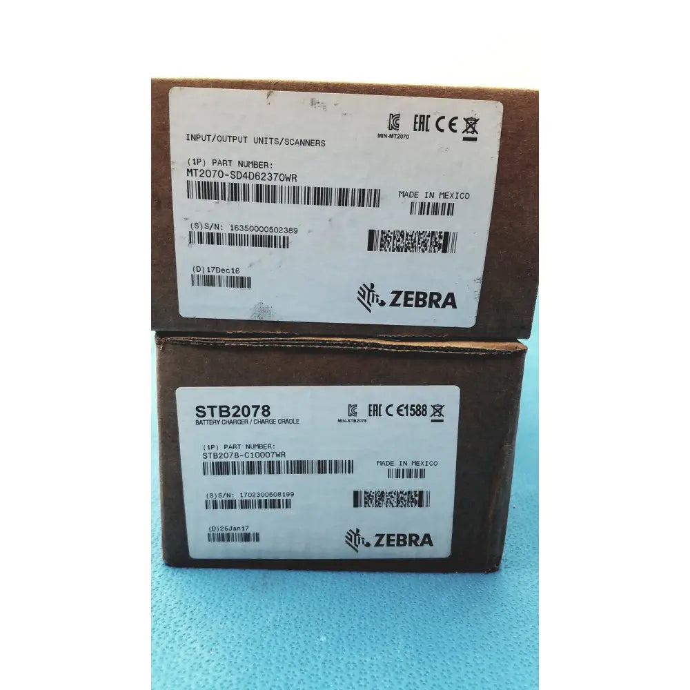 Brown cardboard boxes labeled zebra brand and part numbers for mt2070-sd4d62370wr zebra barcode scanner with battery charger