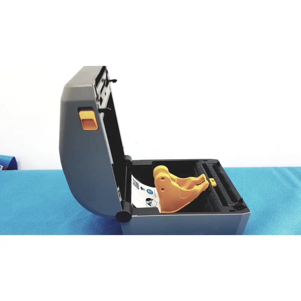 Gray and orange zebra zd620 thermal transfer desktop label printer showing yellow plastic component inside housing