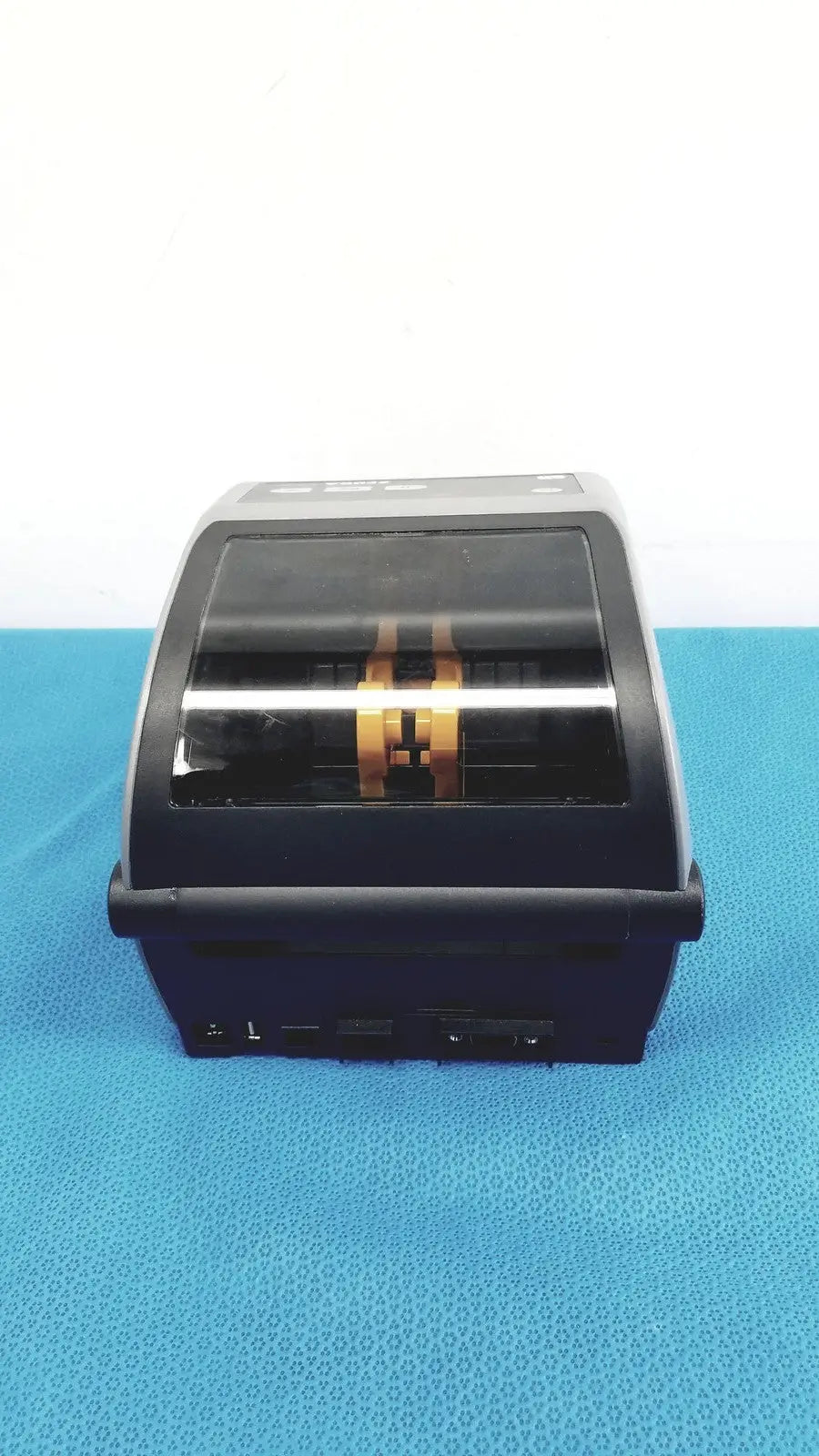 Black and silver zebra zd620 thermal transfer desktop label printer with transparent front panel showing gold internal components