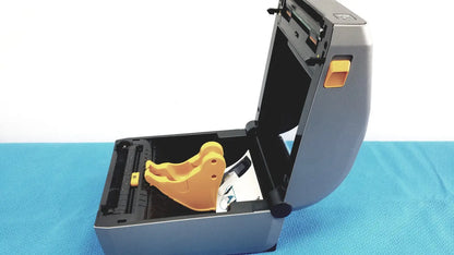 Gray zebra zd620 thermal transfer desktop label printer with yellow plastic component inside its open casing