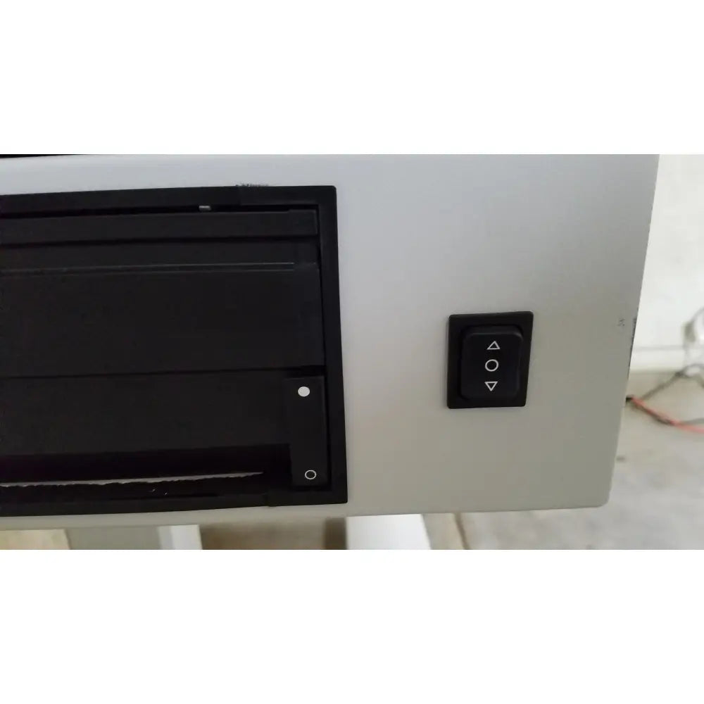 Black rectangular cd dvd drive with matte finish mounted on light gray zeiss humphrey visual field analyzer model 740