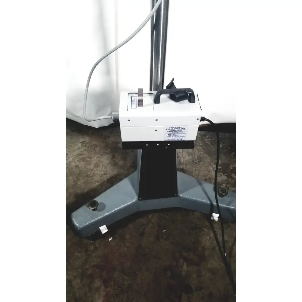 White rectangular zeiss opmi-1 prescott’s mark ii microscope with black handle and base mounted on gray floor stand