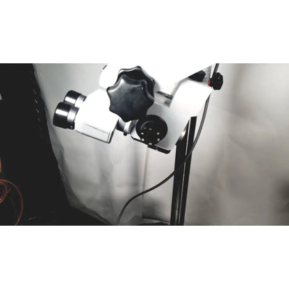 White and black dual-lens zeiss opmi-1 prescotts mark ii stereo microscope mounted on a floor stand with adjustable knobs