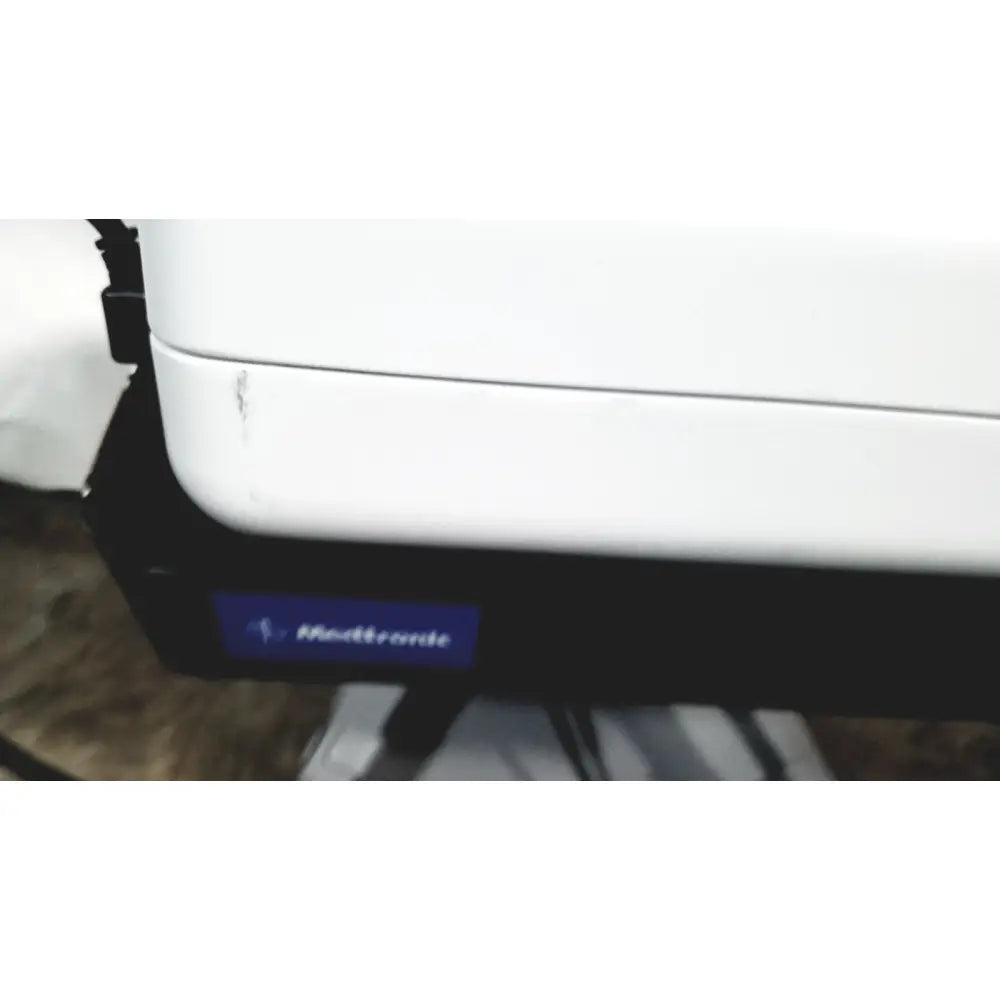 White medtronic zepto precision pulse capsulotomy device with black base and blue logo alongside zepto power console with stand