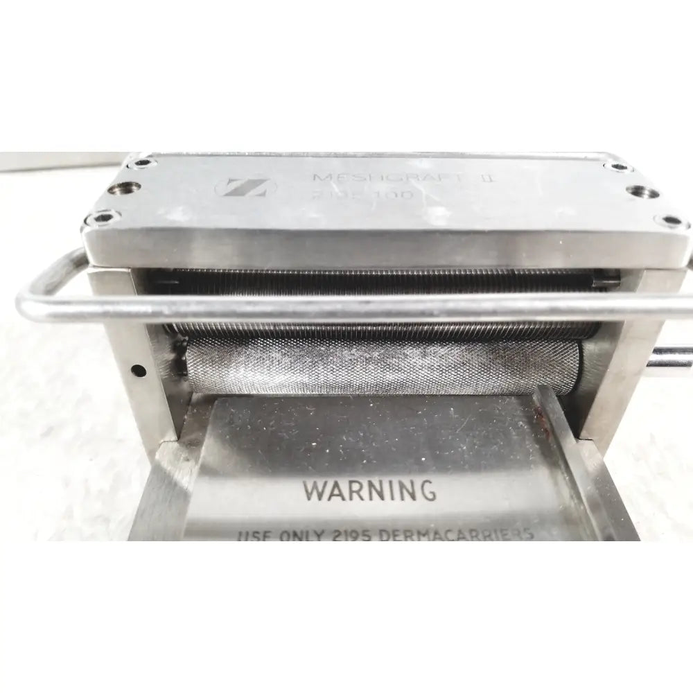 Silver metallic zimmer meshgraft dermatome ii 2195-100 with textured rollers and engraved branding for skin grafts