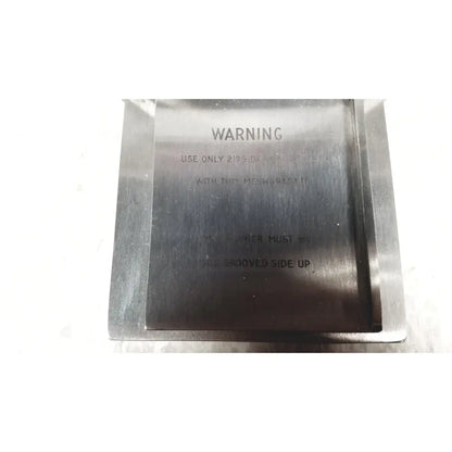 Silver metallic rectangular mesh plate with engraved warning text on the back side of zimmer meshgraft dermatome ii 2195-100
