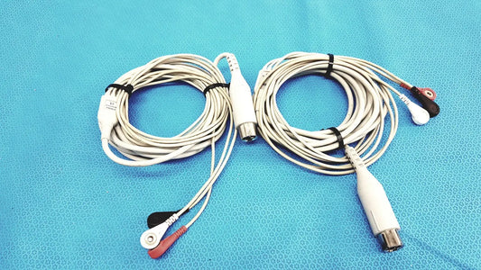 White Zoll 3-lead ECG EKG patient monitoring cables with red and black electrode tips coiled on a blue surface