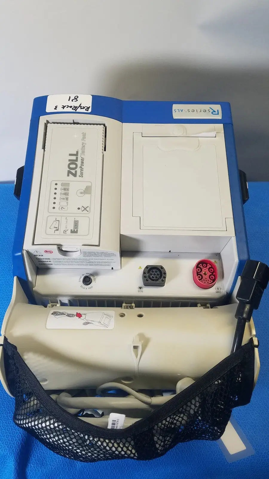 Blue and white zoll r series als patient monitor with surepower battery pack and beige carrying bag
