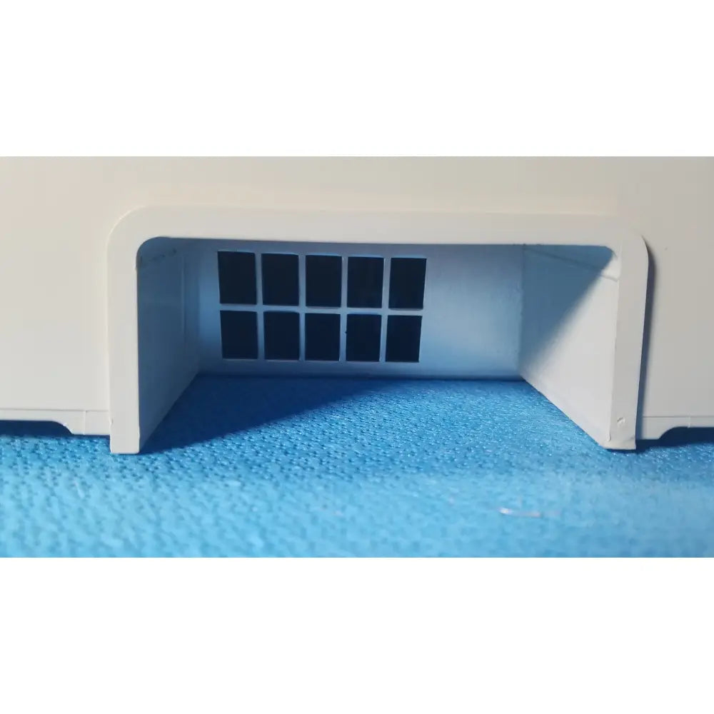 White plastic model of a garage entrance with black grid windows for zoll surepower bay charger station ipx1