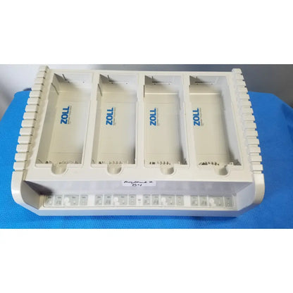 White plastic zoll defibrillator paddle tray with four compartments marked zoll for zoll surepower 4 bay charger station ipx1