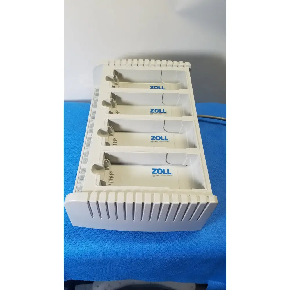 White plastic zoll surepower 4 bay charger station ipx1 with four labeled zoll slots for efficient battery charging